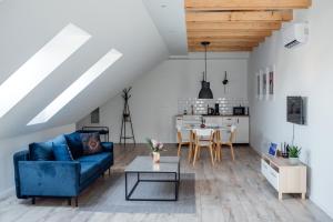 a living room with a blue couch and a table at Style Inn Apartmanok in Veszprém