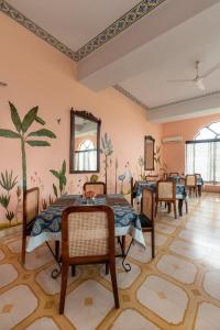a dining room with tables and chairs and a mural on the wall at Gulaab Niwaas Palace in Pushkar