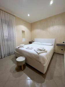 1 dormitorio con 1 cama blanca grande y toallas. en B&B Il Cuore del Borgo, en Papasidero