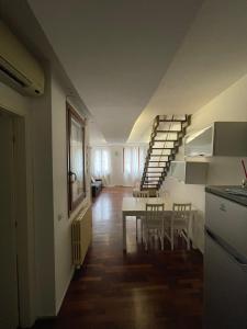 uma cozinha e sala de jantar com uma escada num quarto em Casa Della Valle em Fano