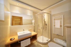 een badkamer met een wastafel, een douche en een toilet bij Hotel Isabella in Merano