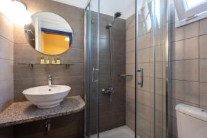 a bathroom with a sink and a glass shower at Sunset Hotel in Agios Ioannis Kaspaka
