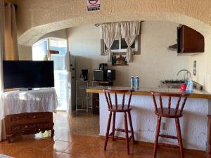 uma cozinha com um balcão e dois bancos de bar em Casa de la Abuela em Ajijic