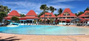 une grande piscine devant un complexe hôtelier dans l'établissement La Perle des Caraïbes, à Sainte-Anne