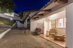 patio białego domu z krzesłem i kwiatami w obiekcie Hotel Butterfly - Il Nido d'Amore Bologna w mieście Monzuno