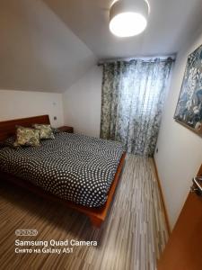a small bedroom with a bed and a window at Bemar Loft in Costa da Caparica