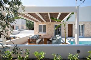 un patio con tavolo, sedie e piscina di Utopia Eco Retreat a Città di Skiathos
