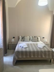 a white bedroom with a large bed with pillows at Vittorio Emanuele house in Catania