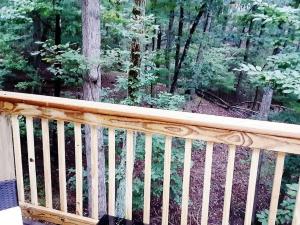 a wooden deck with a view of a forest at Mountain Gem in McGaheysville