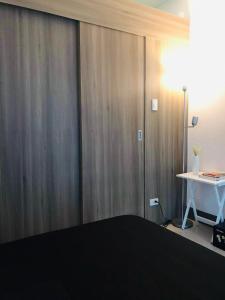 a bedroom with a bed and a desk and a table at Cozy Bedroom FAME Condo Greenfield EDSA MRT Shaw in Manila