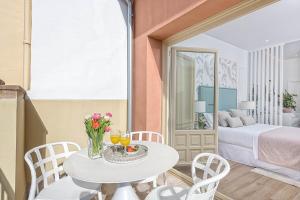 a room with a table and chairs and a bed at iloftmalaga Calle Madre de Dios in Málaga