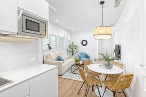 a kitchen and a living room with a table and chairs at iloftmalaga Calle Madre de Dios in Málaga
