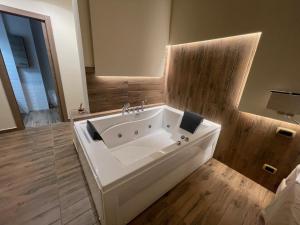a large white bath tub in a bathroom with wooden floors at JSK Suite in Rome