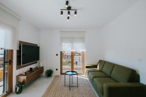 a living room with a green couch and a tv at Oleander Urban Suites, high-speed internet, beach at 250, PET friendly in Trogir