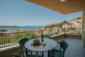 un tavolo e sedie su un balcone con vista sull'acqua di Oleander Urban Suites, high-speed internet, beach at 250, PET friendly a Trogir