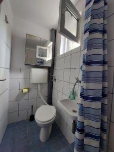 a small bathroom with a toilet and a sink at Apartment Rupena in Klimno +42 photos