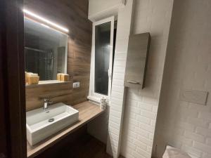 un bagno con lavandino e specchio di JSK Suite a Roma