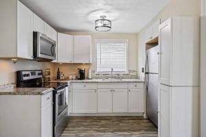 a kitchen with white cabinets and a white refrigerator at The Spanish Beach Home only 10mins from the beach! in Largo