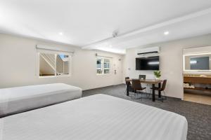 Habitación de hotel con 2 camas y mesa en Good Nite Inn Calabasas en Calabasas
