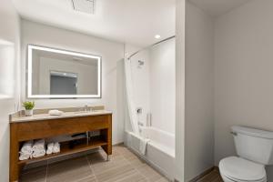 a bathroom with a toilet and a sink and a tub at Good Nite Inn Calabasas in Calabasas