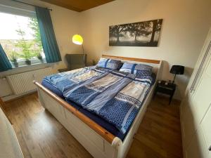 a bedroom with a bed with a blue and white comforter at Zur Söhre 
