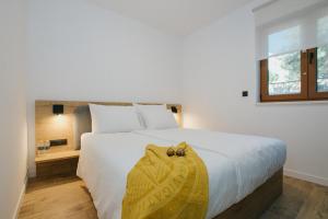 a bedroom with a large white bed and a window at Oleander Urban Suites, high-speed internet, beach at 250, PET friendly in Trogir