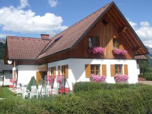 a house with chairs and flowers in the yard at Appartement Pölzl Öblarn Region Schladming Dachstein in Öblarn