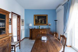a dining room with a wooden table and blue walls at Appartamento Talenti in Rome
