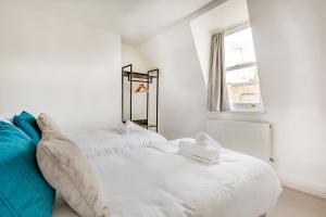 Cette chambre blanche dispose de 2 lits et d'une fenêtre. dans l'établissement Modern 2 Bed Apartment in Central London, Kensington, à Londres