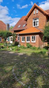 a brick house with a red roof at Adelheidshof in Magelsen