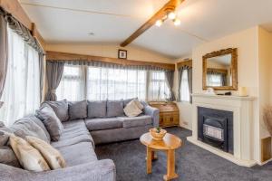 a living room with a couch and a fireplace at Great Dog Friendly Caravan For Hire At North Denes In Suffolk Ref 40068nd in Lowestoft