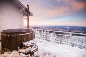 - Balcón cubierto de nieve de una casa con bañera de hidromasaje en Chata Jiriho na Seraku en Bělá pod Pradědem