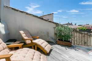a patio with two chairs and a couch on a balcony at Nuit Etoilée in LʼIsle-sur-la-Sorgue
