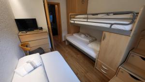 a small room with two bunk beds and a television at Apartment Di Lembah in Wiler