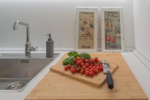 a cutting board with tomatoes and other vegetables on a kitchen counter at Ginepro & Salvia Apartments in Como by Rent All Como in Como