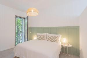 a bedroom with a white bed and a window at Ginepro & Salvia Apartments in Como by Rent All Como in Como