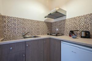 a kitchen with a sink and a counter top at Sunset Hotel in Agios Ioannis Kaspaka