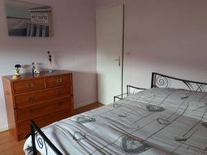 een slaapkamer met een bed en een houten dressoir bij macareux in Binic