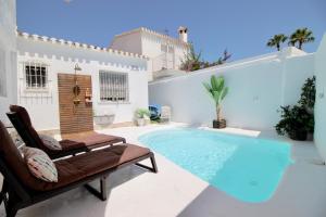 een zwembad in een achtertuin met een bank en een stoel bij Julitte 91 by homeprive in Denia