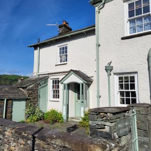 a man on the roof of a white house at Peggy Hill Cottage in Ambleside