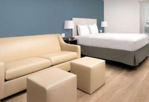 a hotel room with a bed and a couch at WoodSpring Suites Littleton-South Denver in Littleton