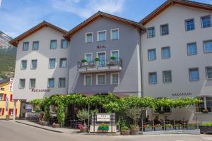 un gran edificio blanco con un cartel delante en Hotel Arkanum en Salgesch