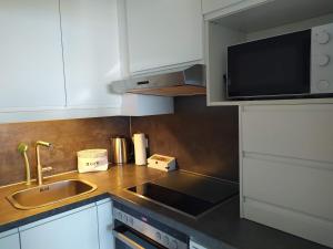 eine Küche mit einer Spüle und einer Mikrowelle in der Unterkunft Haus Brandenburg App 43 in Westerland