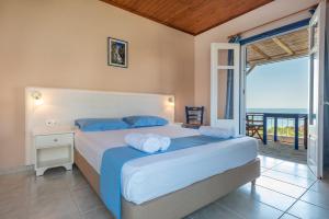 a bedroom with a bed with a view of the ocean at Sunset Hotel in Agios Ioannis Kaspaka