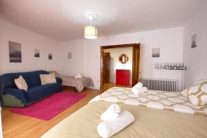 - un salon avec deux lits et un canapé bleu dans l'établissement CUENCALOFT RAMÓN Y CAJAL 18, à Cuenca
