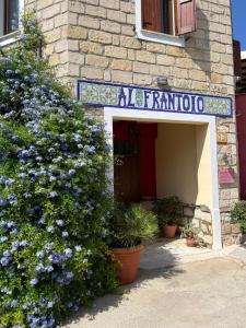 a building with a sign for a pharmacy with purple flowers at B&B Alfrantoio Valderice in Valderice