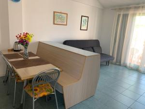 une cuisine et une salle à manger avec une table et une chaise dans l'établissement Brezza marina, à SantʼAndrea Apostolo dello Ionio