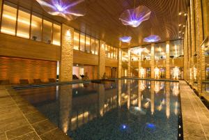 a swimming pool in a building with lights at Vesper Hotel in Noordwijk aan Zee