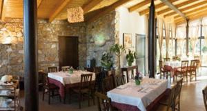 a dining room with tables and chairs and a stone wall at Locanda Dei Cocomeri in Montalto Uffugo