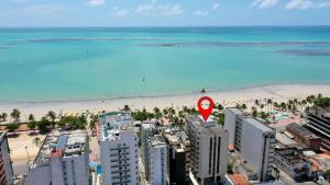 uma vista aérea de uma praia e do oceano em Edf Casabela - Apartamento Beira Mar com 2 quartos sendo 1 suíte com vista para as piscinais naturais com ar condicionado em todos os quartos e na sala - 1 vaga de garagem em Maceió